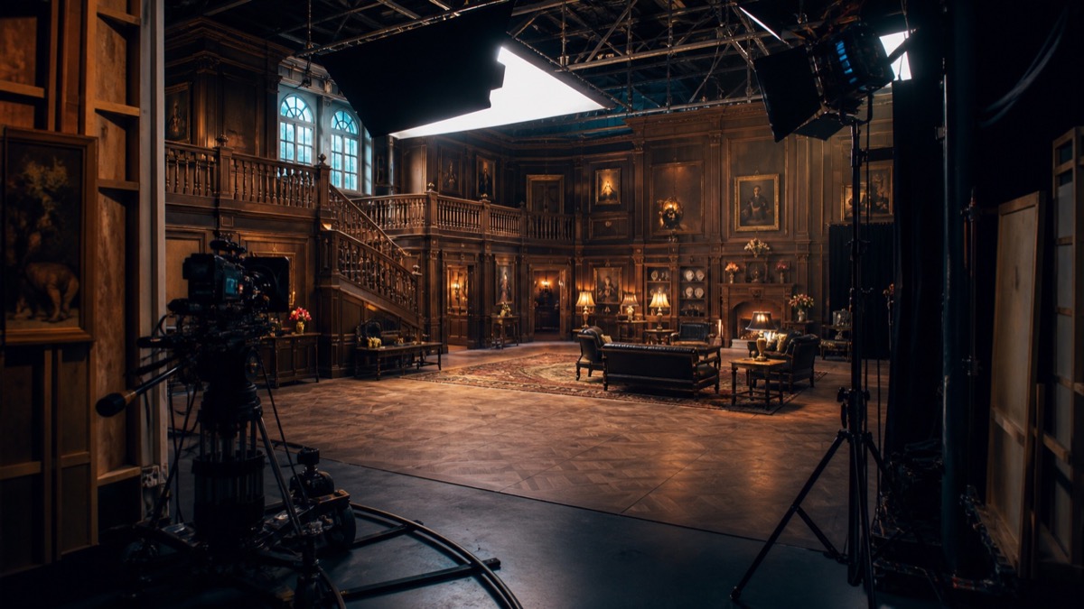 Behind-the-scenes film studio with a detailed interior set, cameras and production lighting